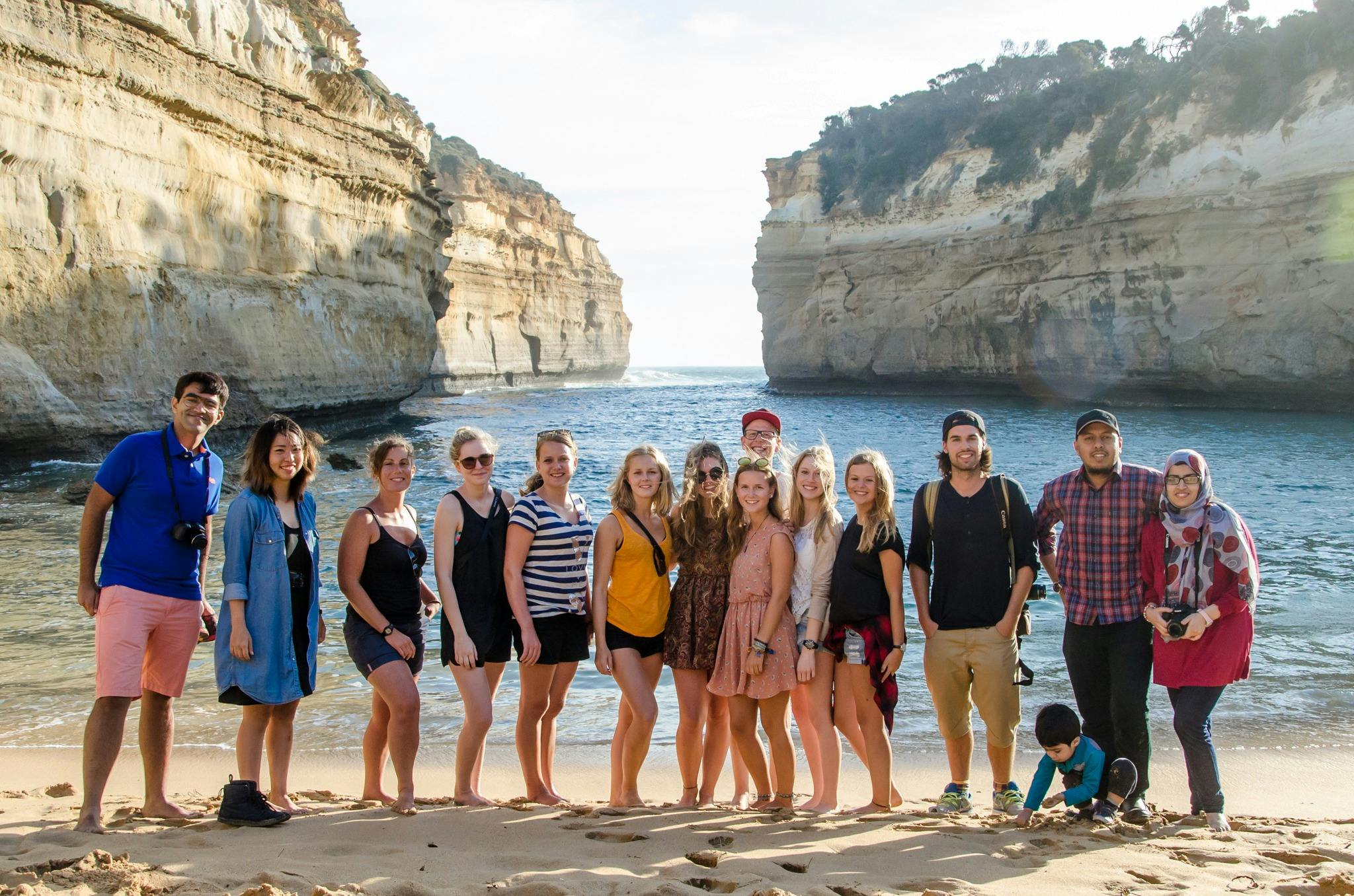 Group of travellers on the beach in front of Loch Ard Gorge located on the Great Ocean Road