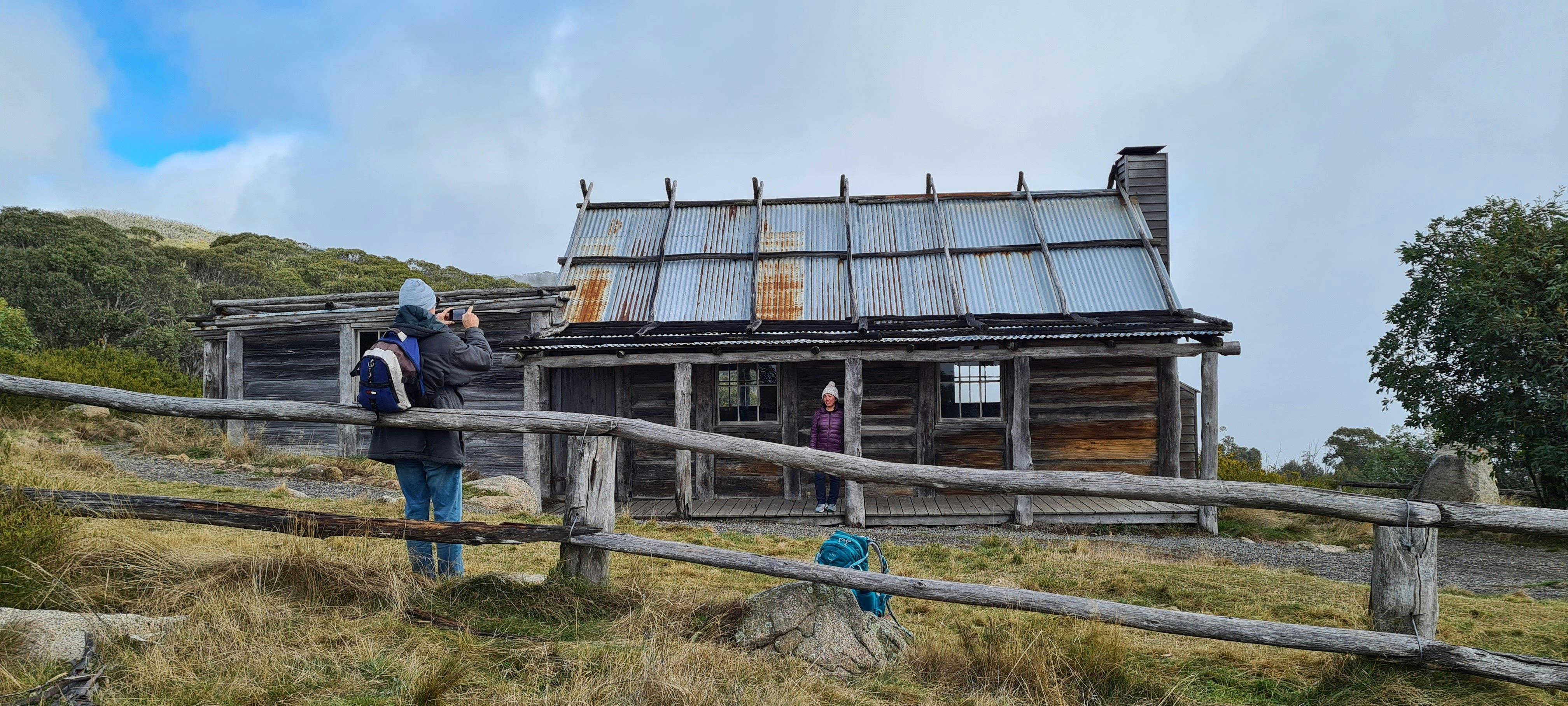 A couple of hikers capturing the magic of Craig's Hut on their camera.