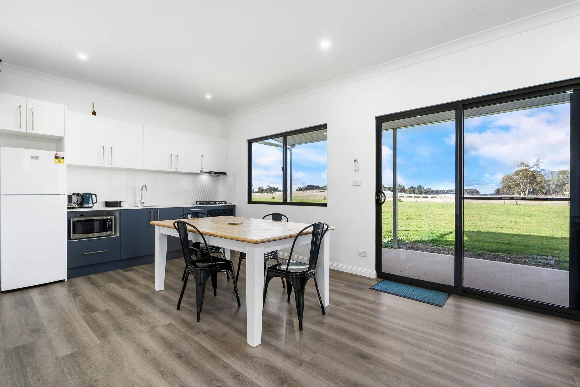 Dining table, blue and white kitchen with all the required amenities for a short-term stay