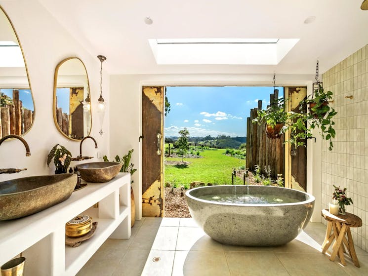 Luxurious bathroom featuring a bathtub with stunning hinterland views surrounded by lush greenery