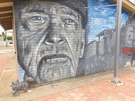 A mural of a train on the side of the toilets
