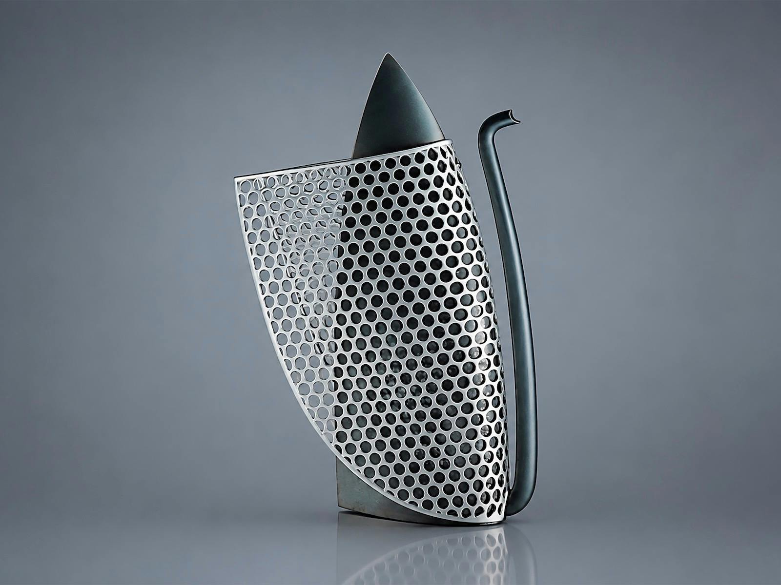 sleek metallic coffee pot covered in perforated mesh with pointed lid