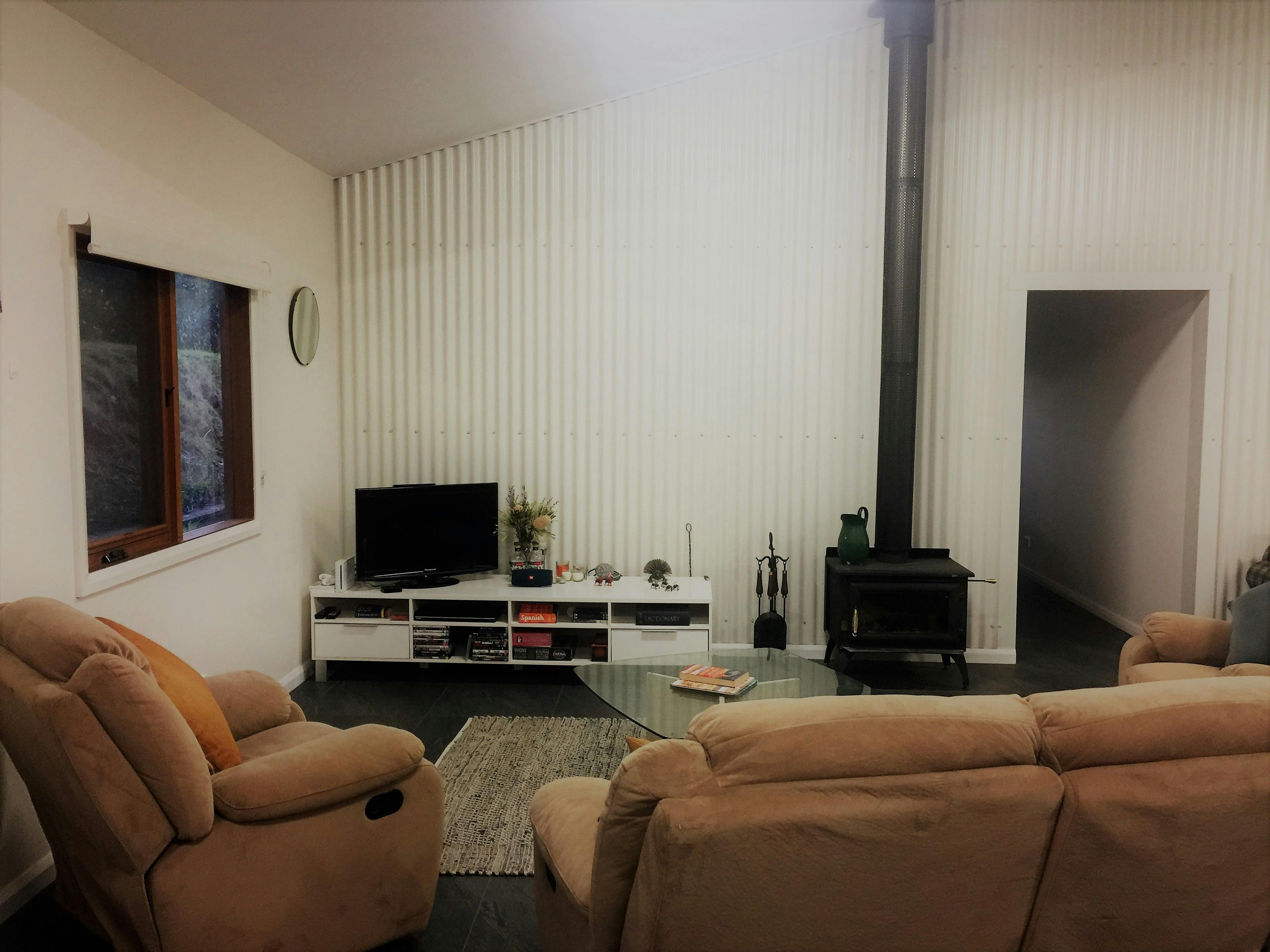 Living room with TV and fireplace and comfy lounges. Firewood provided!