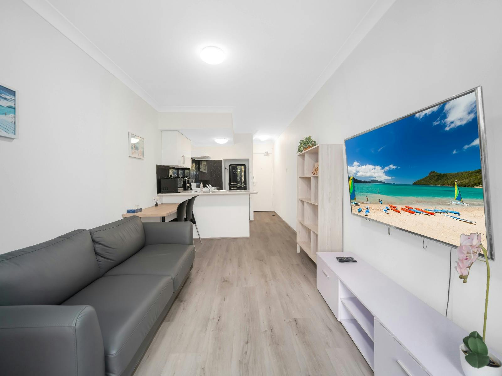 Bright lounge area with comfortable seating, Smart TV and open-plan apartment layout.