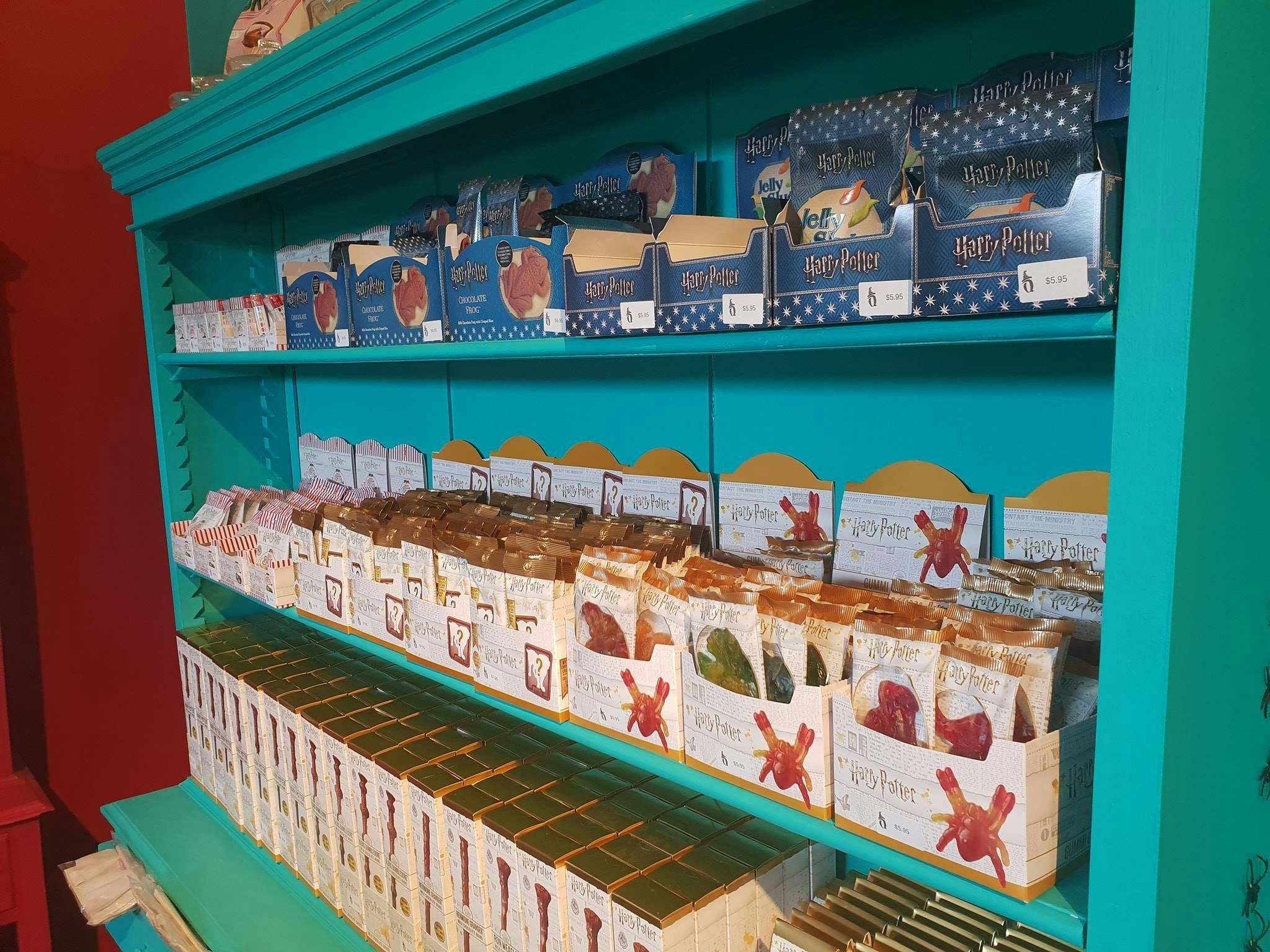 Shelves full of lollies, including chocolate frogs.,