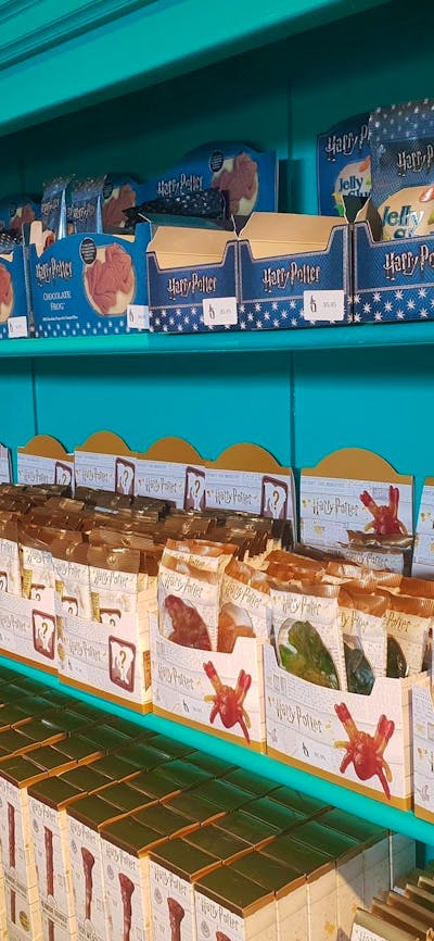 Shelves full of lollies, including chocolate frogs.,