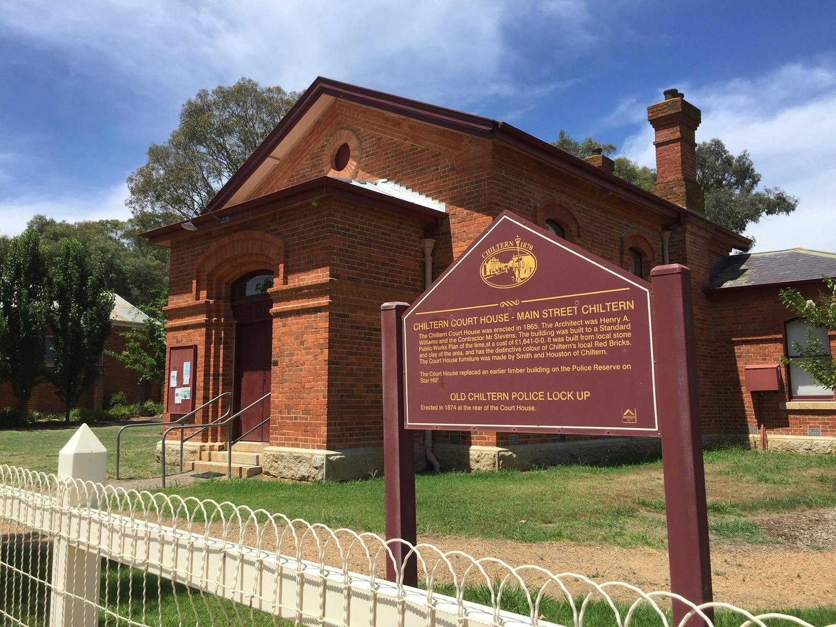 front view of red brick court house with history story board