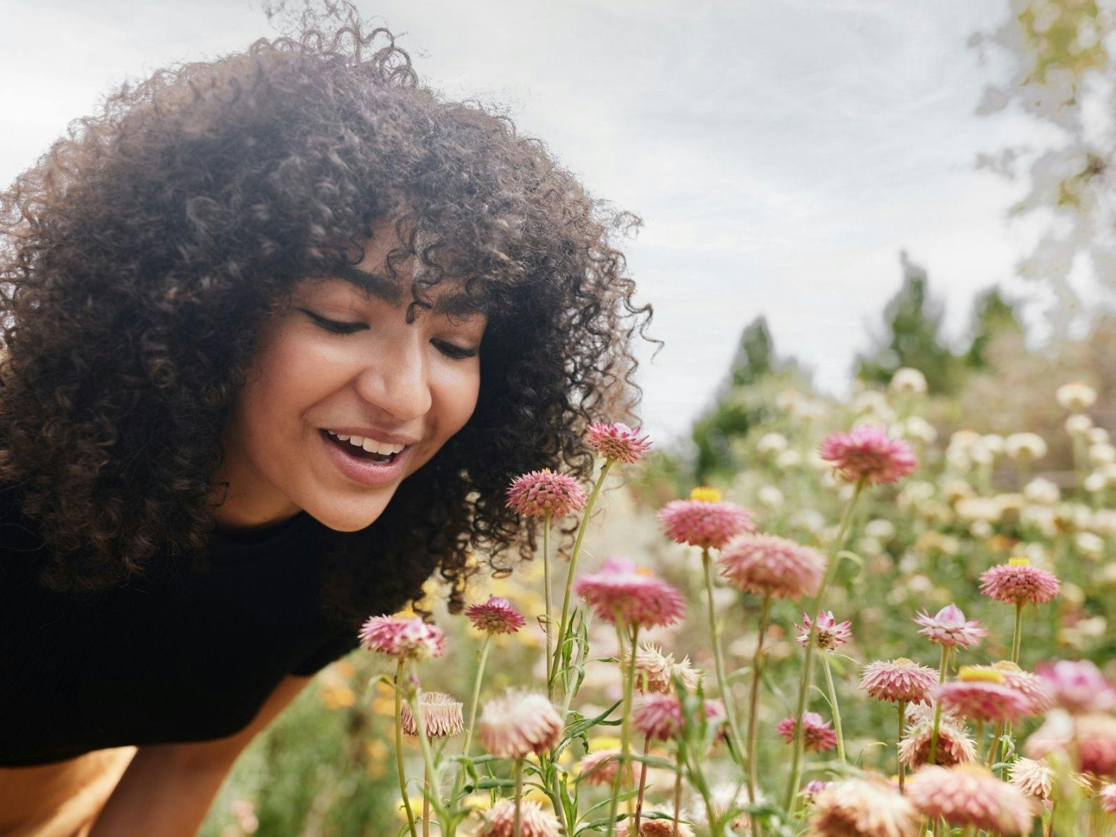 A woman smelling paper daisies