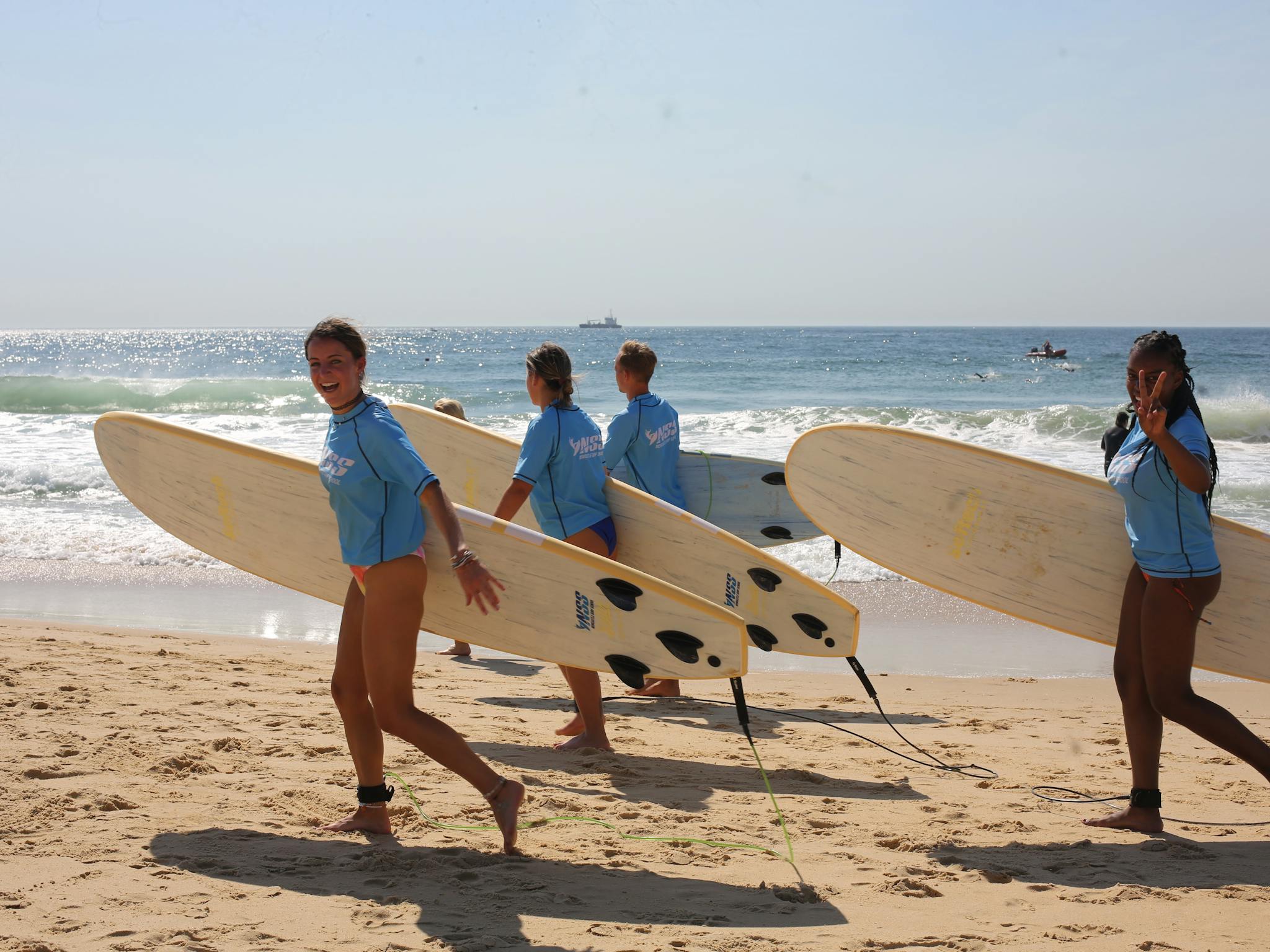 Surfers running to the water