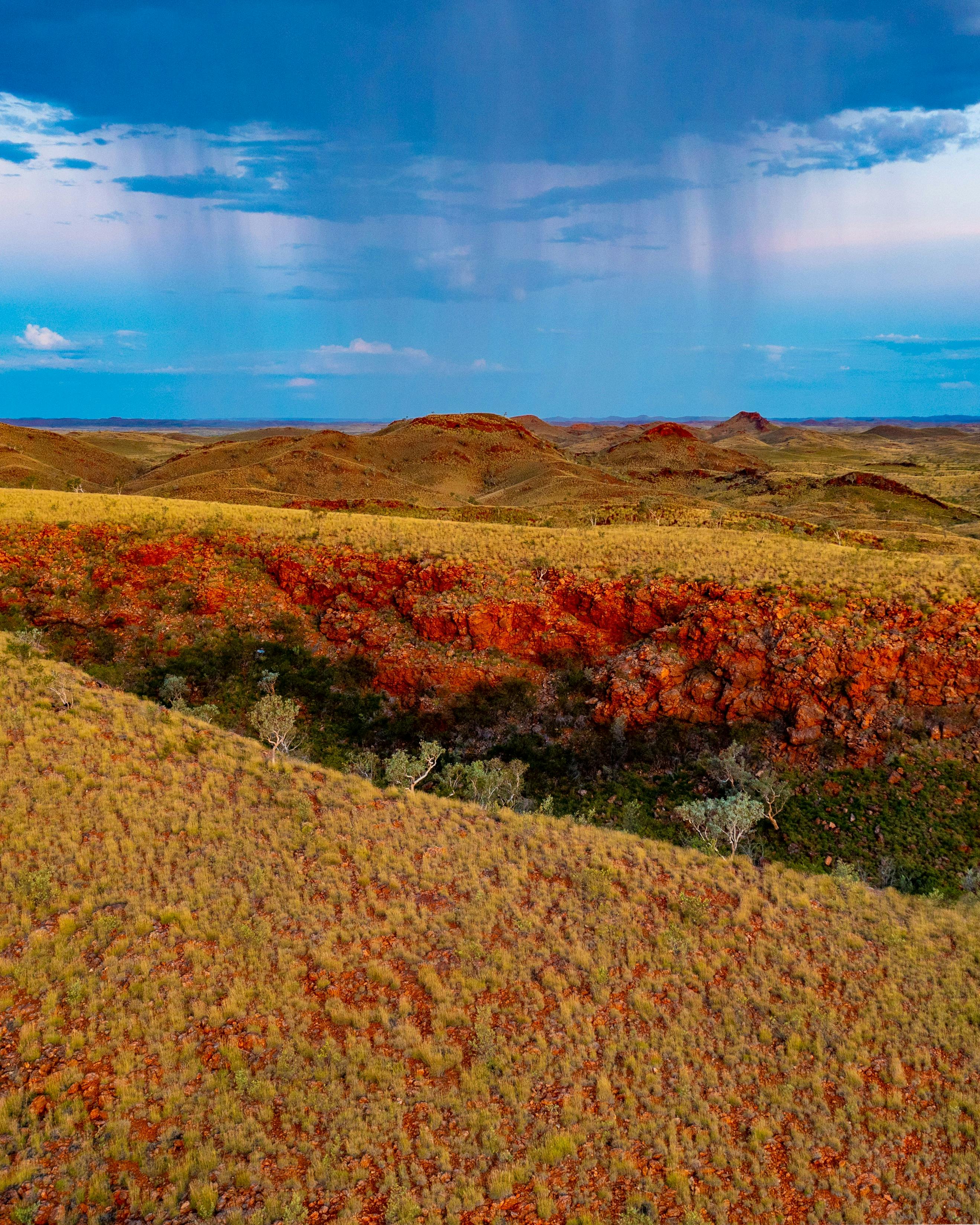 Blue sky over the striking red earth and green vegitation after much needed rain in the Pilbara
