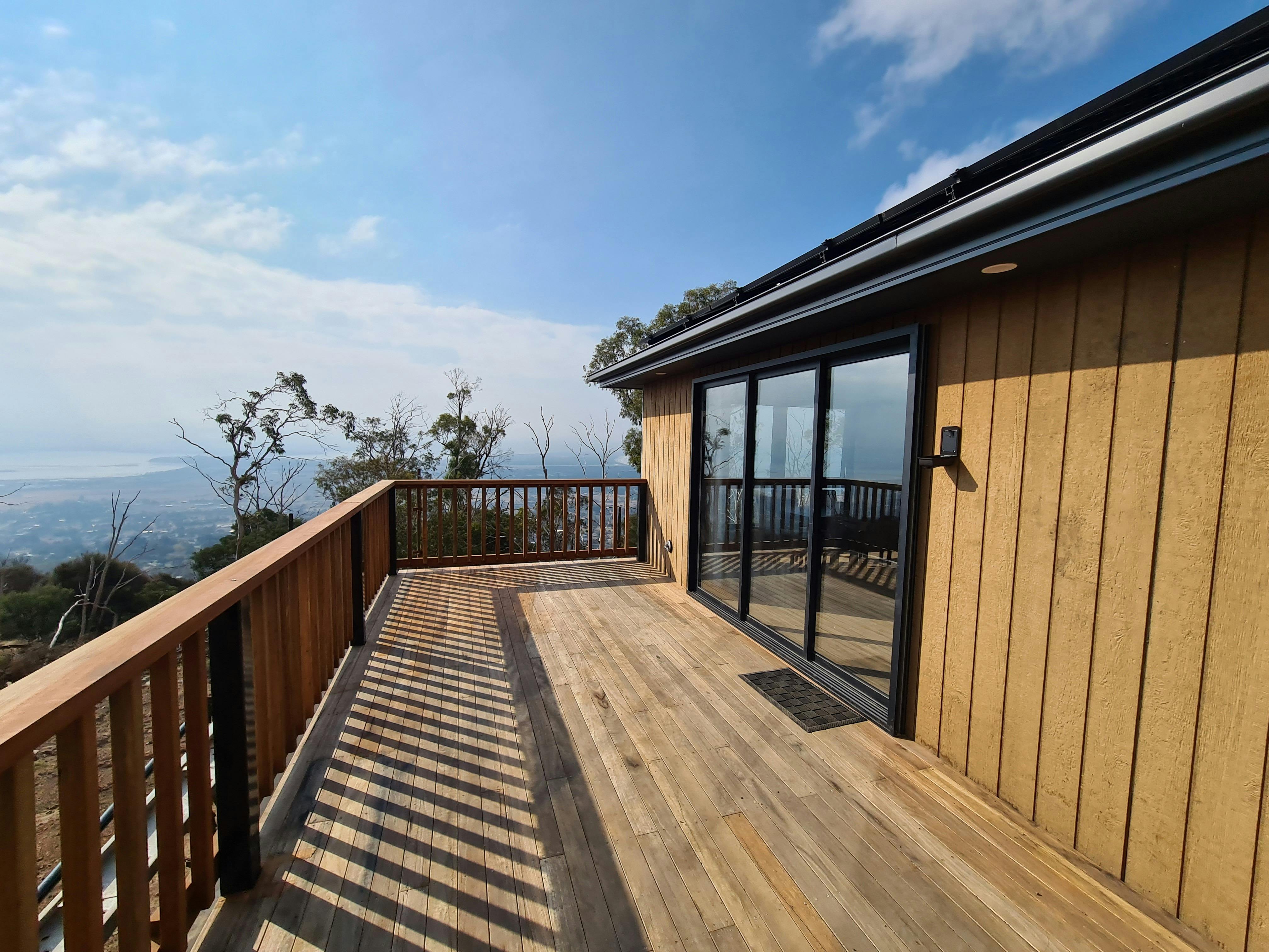 Timber deck outside the cabin overlooking bushland and distant views