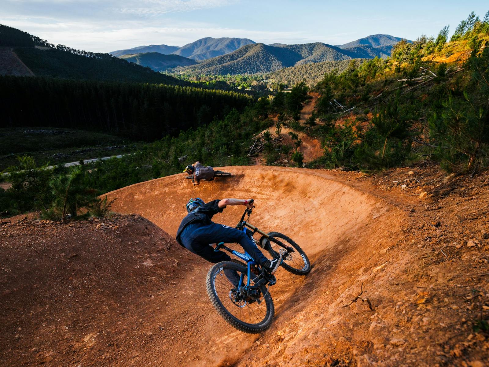 2 Riders on a trail with Bright township and mountains in the background