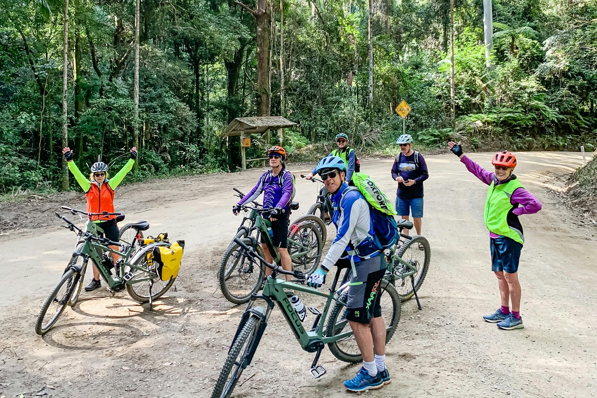 국립공원으로 언덕을 오르기 전에 손을 공중에 든 라이더 그룹이 휴식을 위해 멈췄습니다.