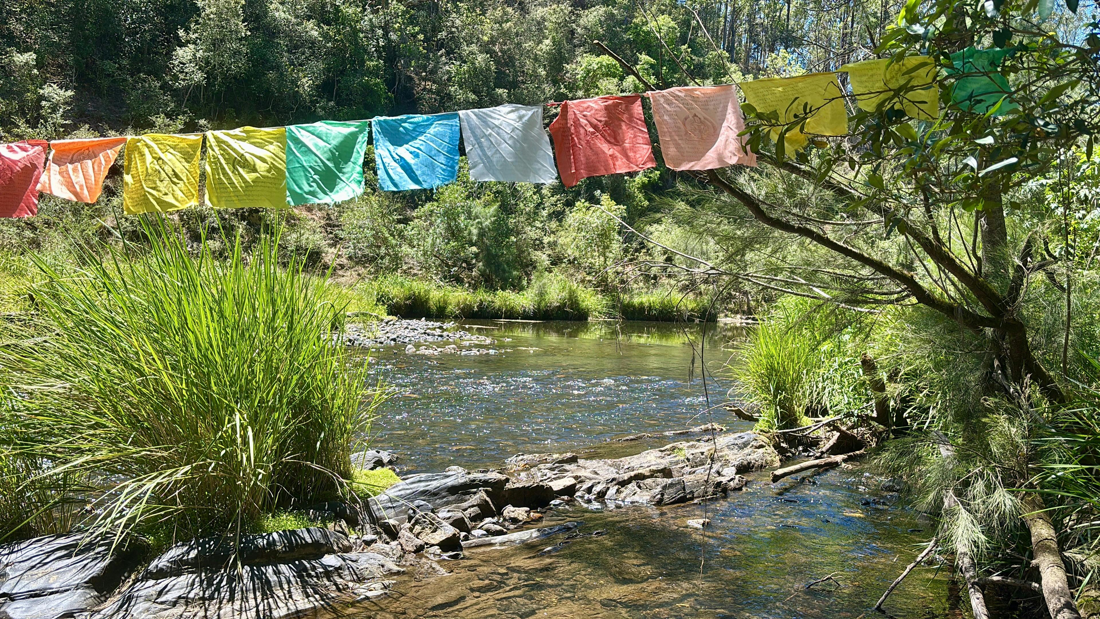 River with crystal clear water, Tibetan prayer flags and clear water for swimming