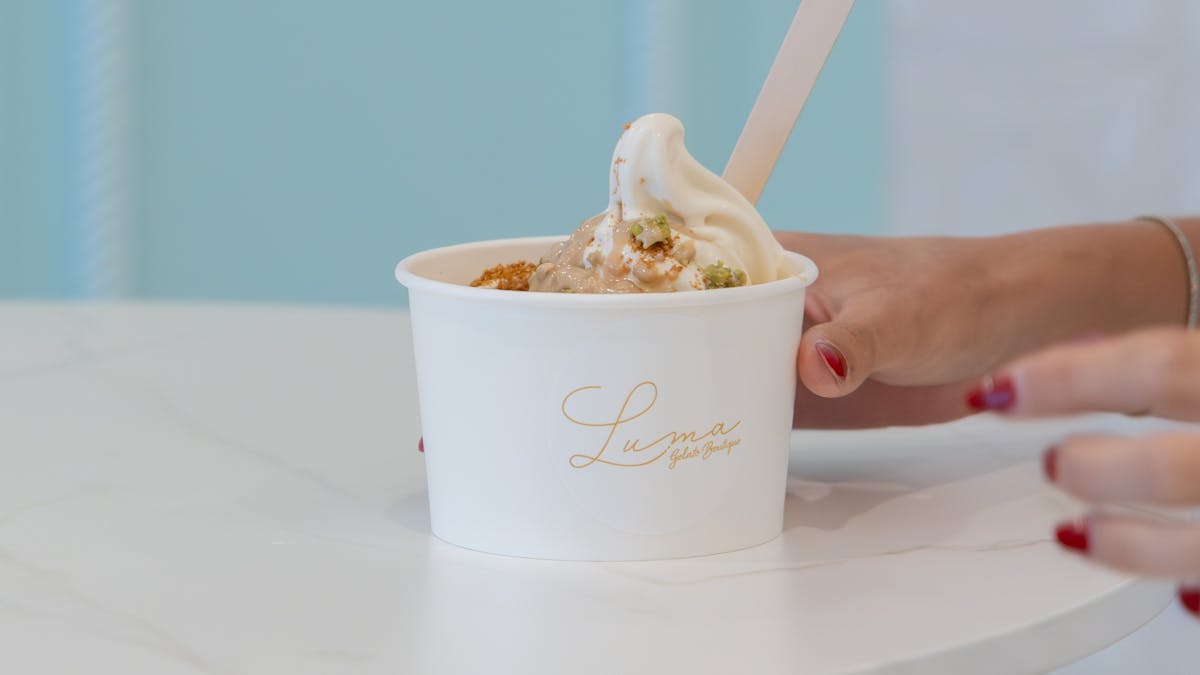A cup of soft serve gelato with toppings at LUMA Gelato on a table