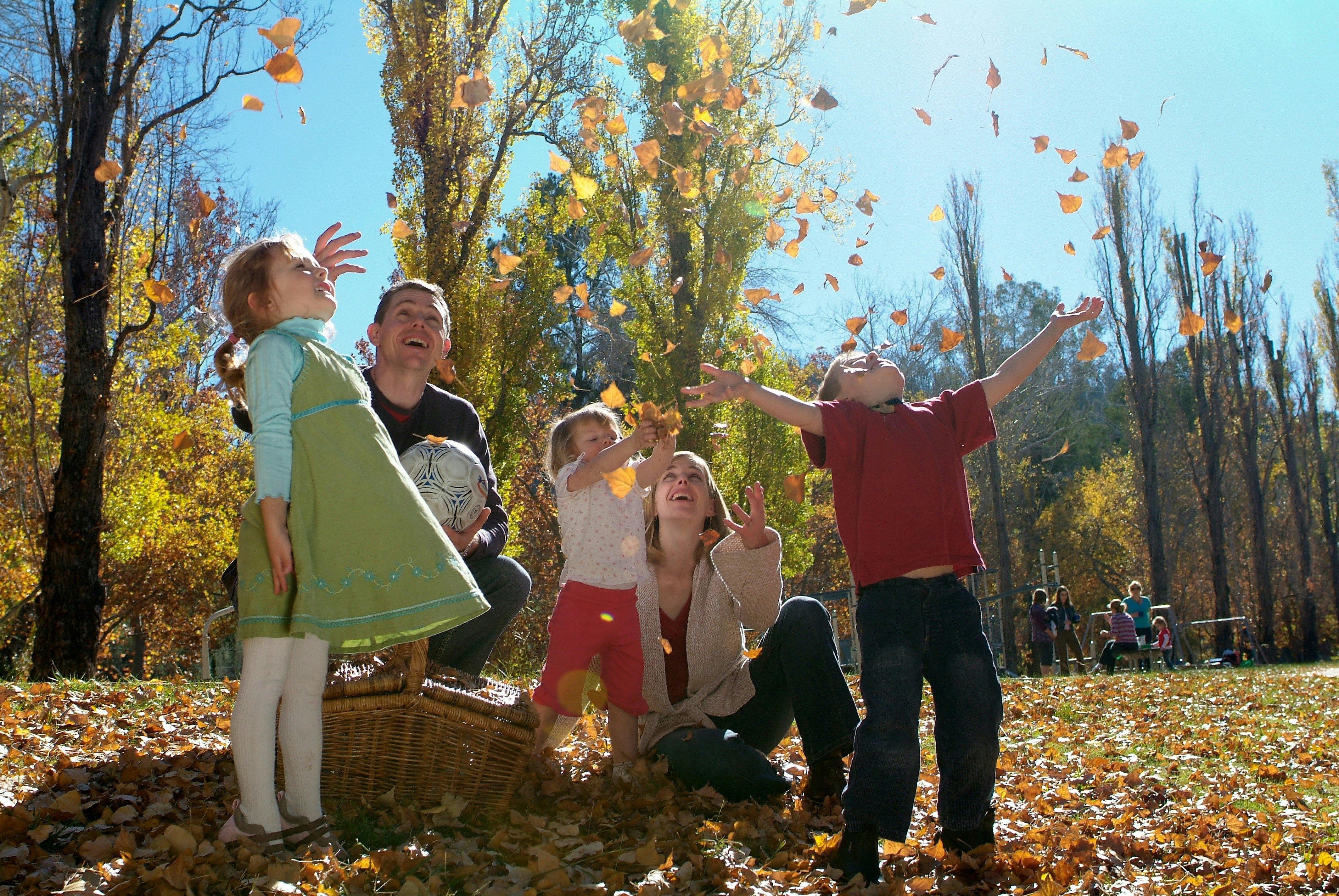 Family playing in the Autumn leaves