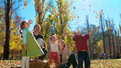Family playing in the Autumn leaves