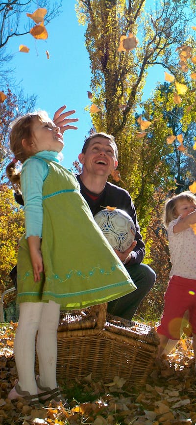 Family playing in the Autumn leaves