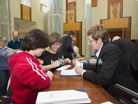 Image of a Visitor Services Officer assisting visitors to Parliament House