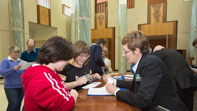 Image of a Visitor Services Officer assisting visitors to Parliament House