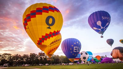 Balloons rising into the sky as dawn breaks
