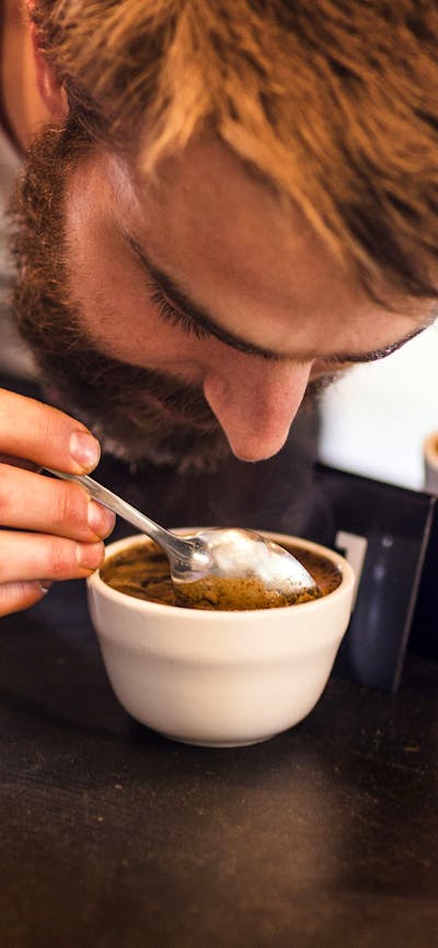 Man inhaling the coffee aroma in his cup