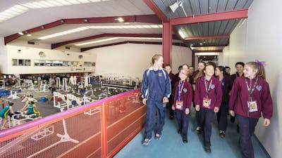 Tour group walking past the athletes training area