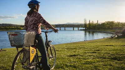 Girl on a Share A Bike bike at the lake