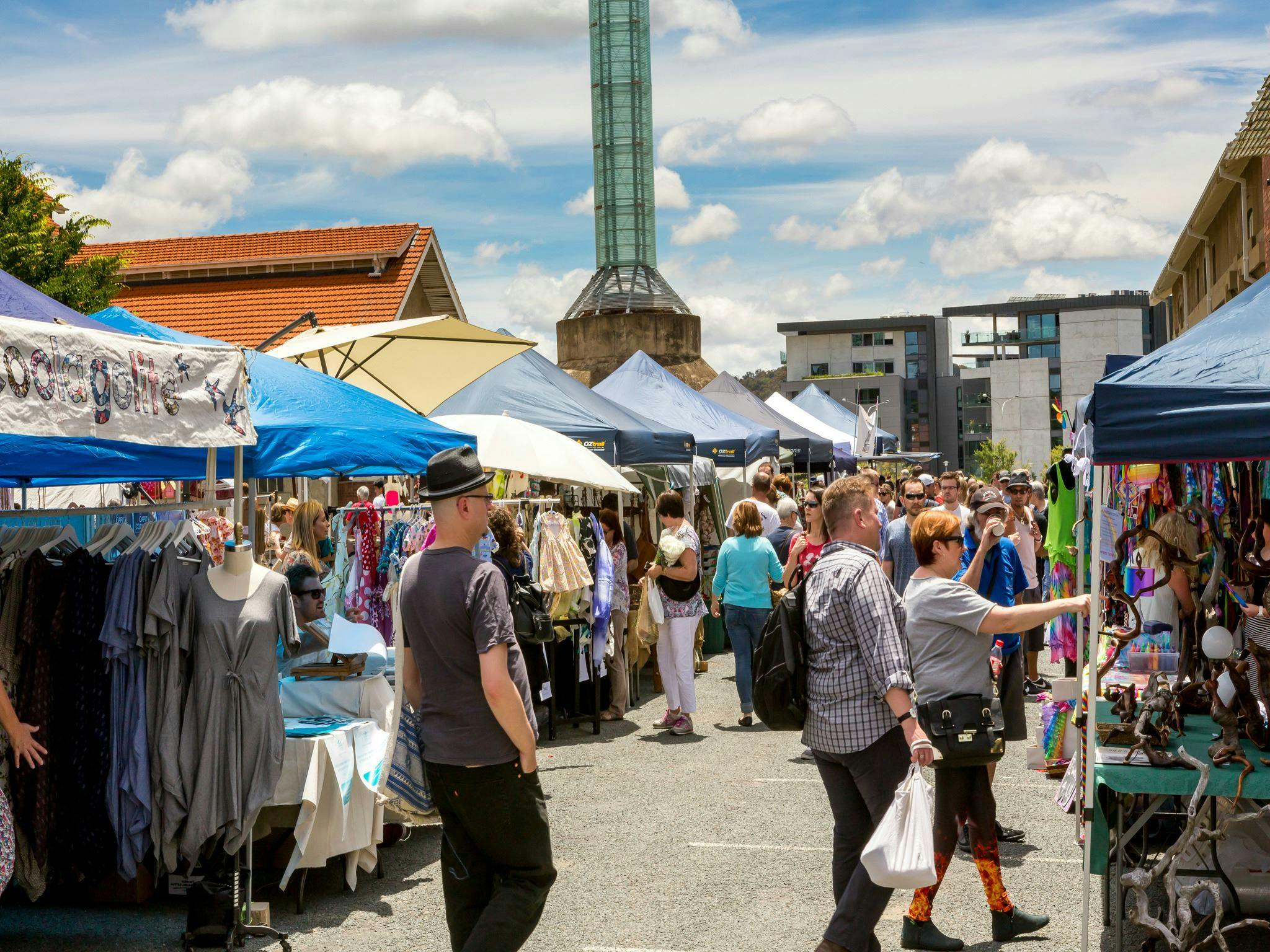 Outdoor stalls and visitors at the front of the Old Bus Depot Markets