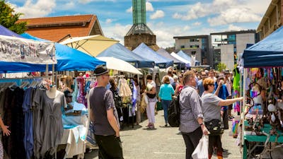 Outdoor stalls and visitors at the front of the Old Bus Depot Markets