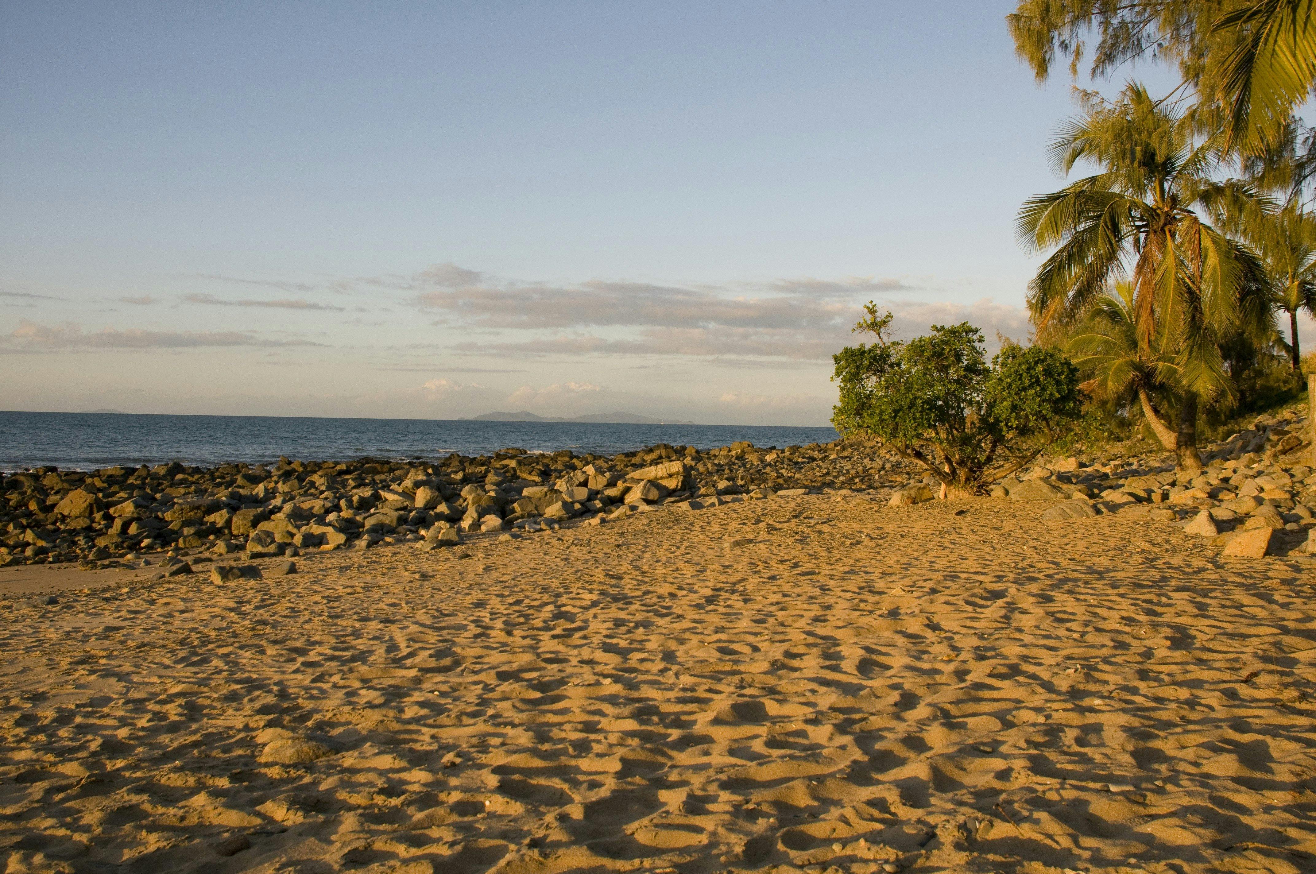 Sand, rocks, palms and sunset ocean views
