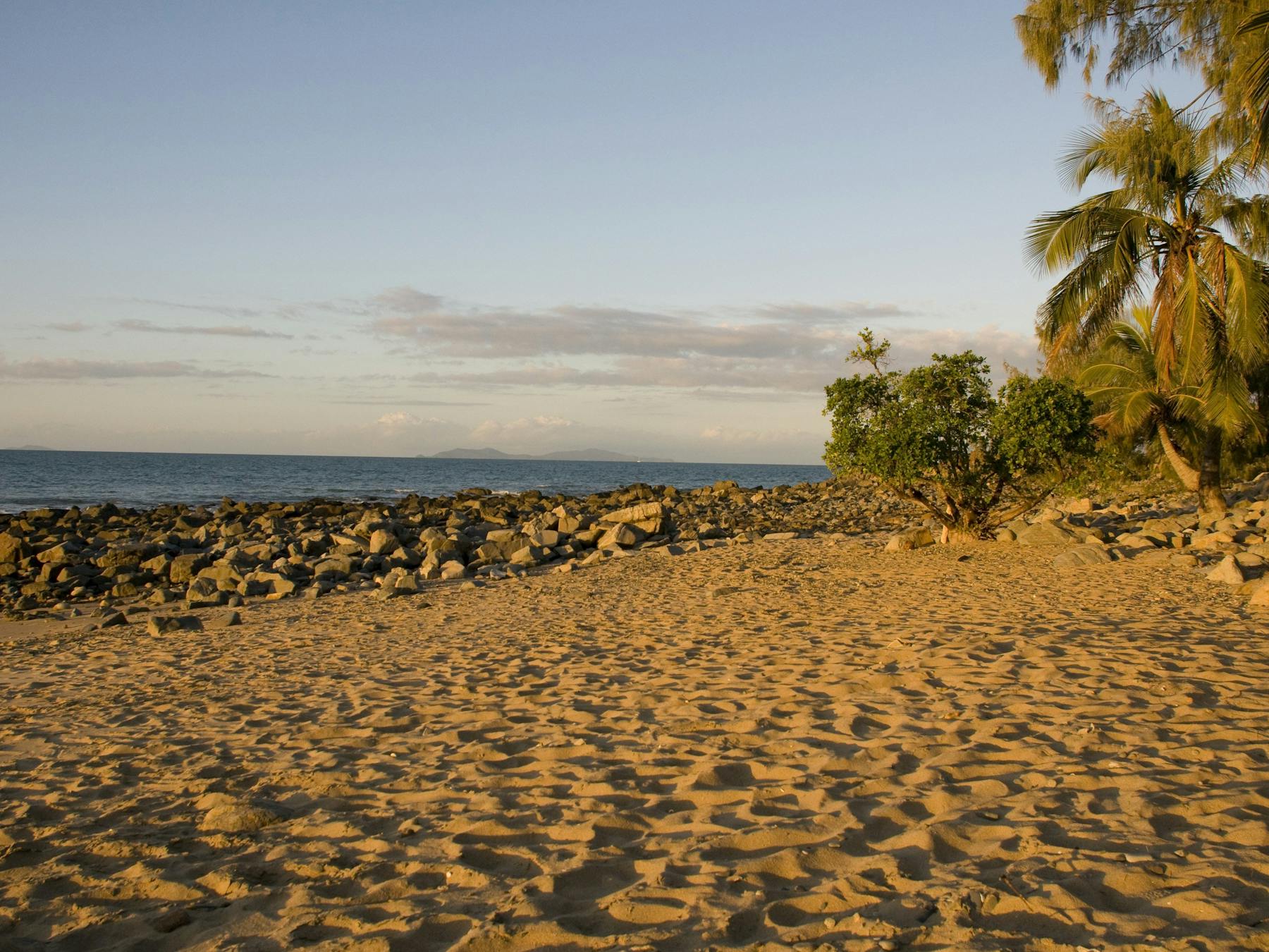 Sand, rocks, palms and sunset ocean views