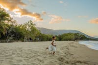 Girl running along Kewarra beach at sunset