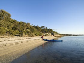 Man brings kayak ashore at Wilsons Promontory
