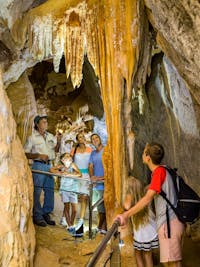 A family explore the Chillagoe caves with a ranger in Chillagoe National Park, North Queensland.