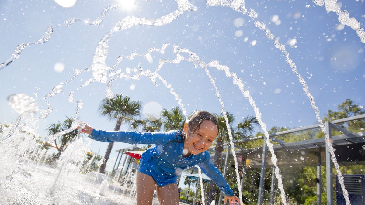 East Shores Parklands, Child running under water spray at the East Shores Precinct in Gladstone East Shores Parklands, Child running under water spray at the East Shores Precinct in Gladstone