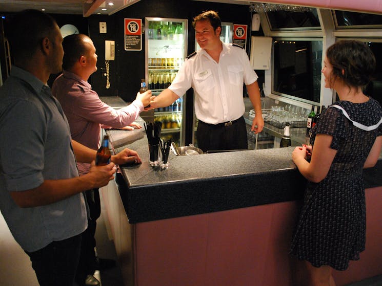 Peter serving drinks to patrons at the bar on 'The Princess'