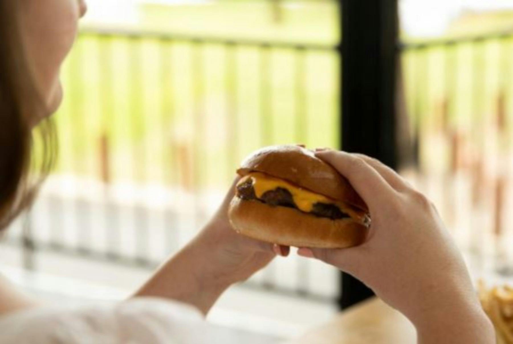 woman holding a burger
