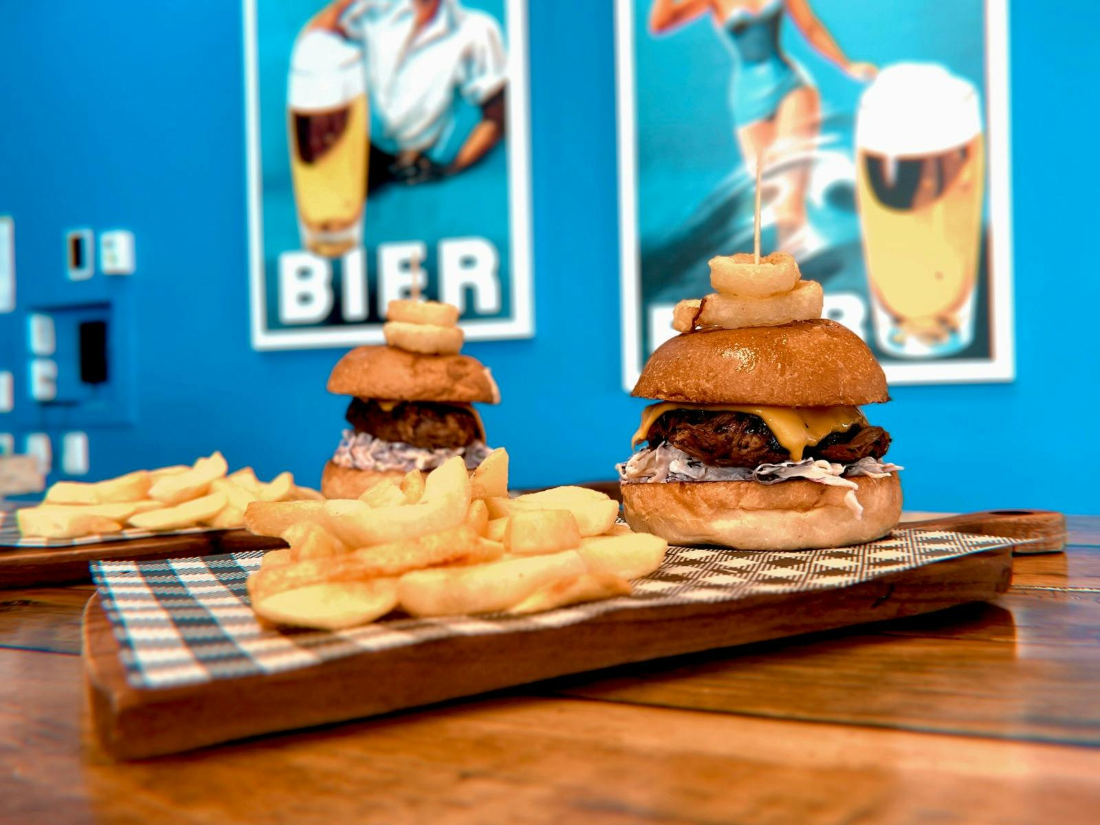 Hot chips and burgers in front of our blue branding and wall art