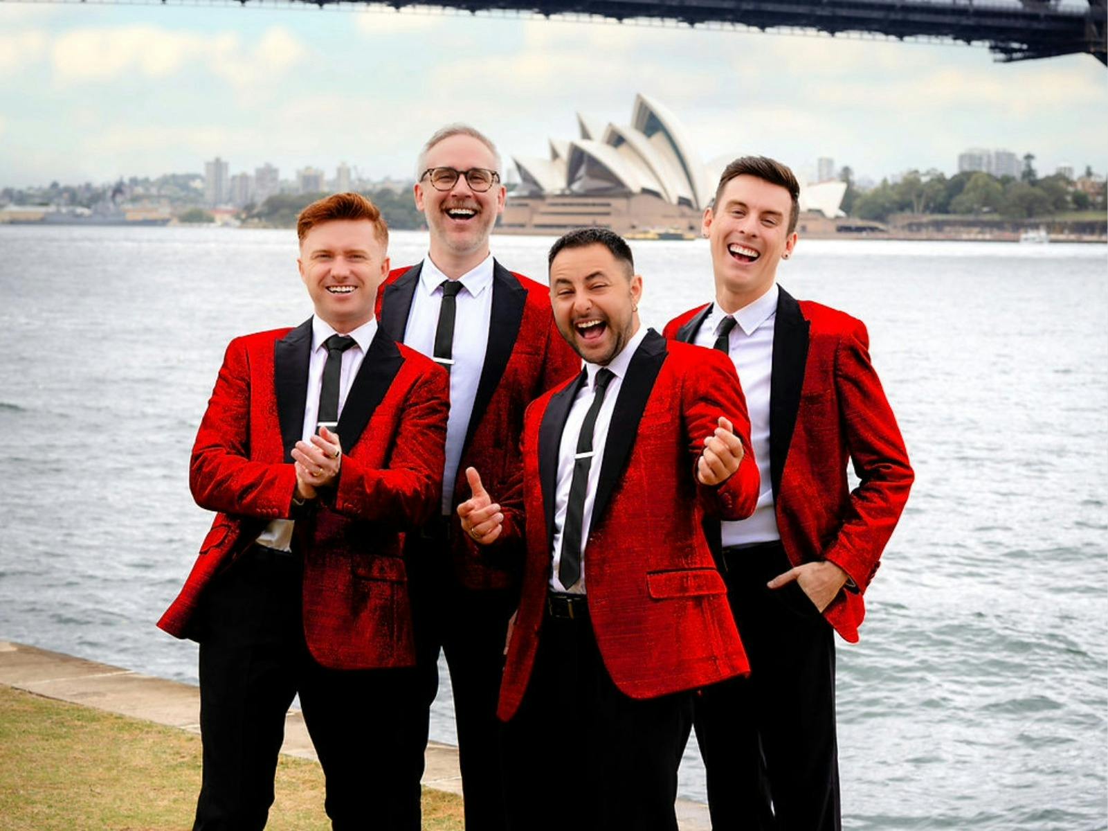 four men in red jackets looking at the camera and smiling