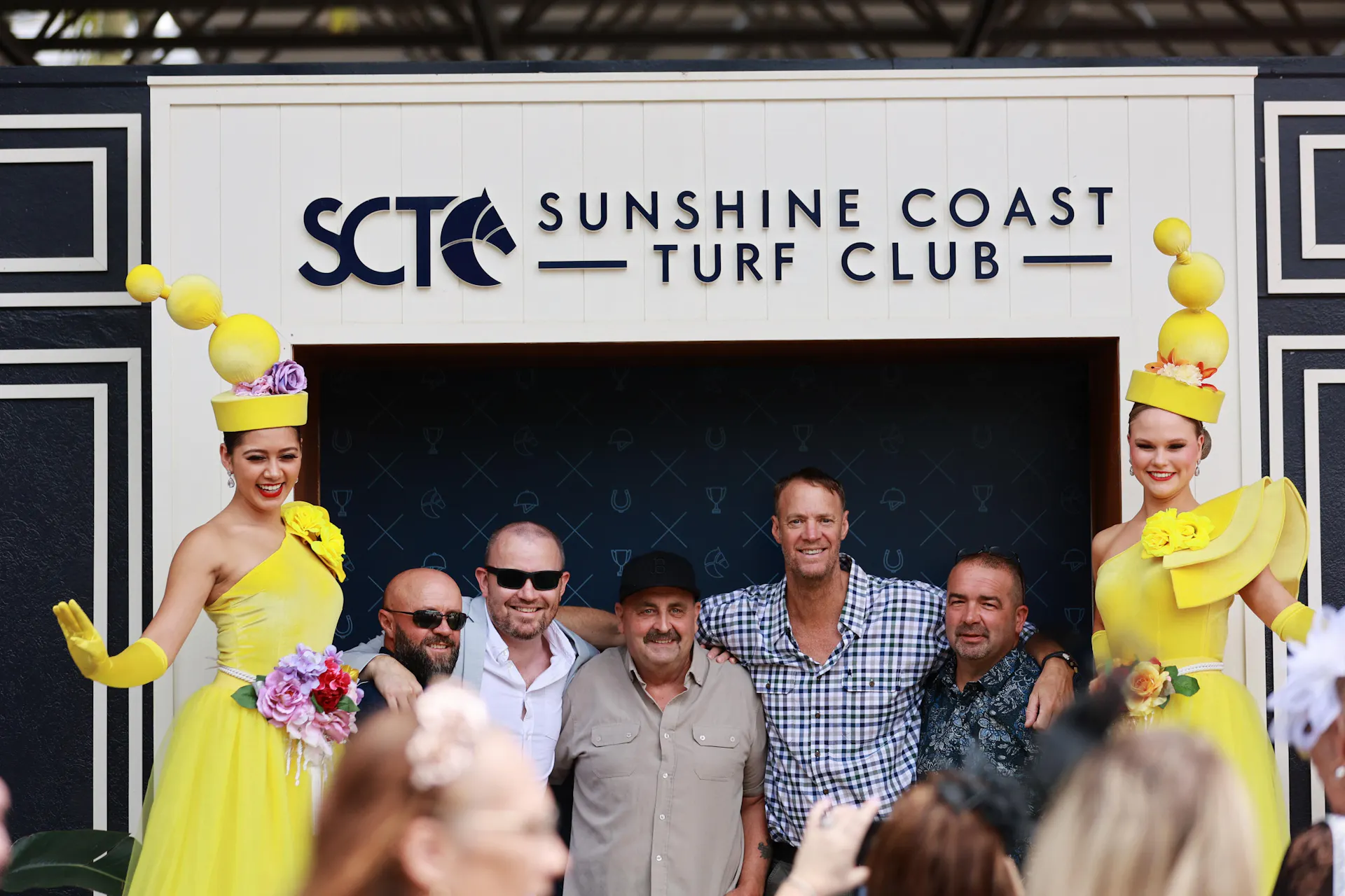 Group of friends having their photo taken with stilt walkers