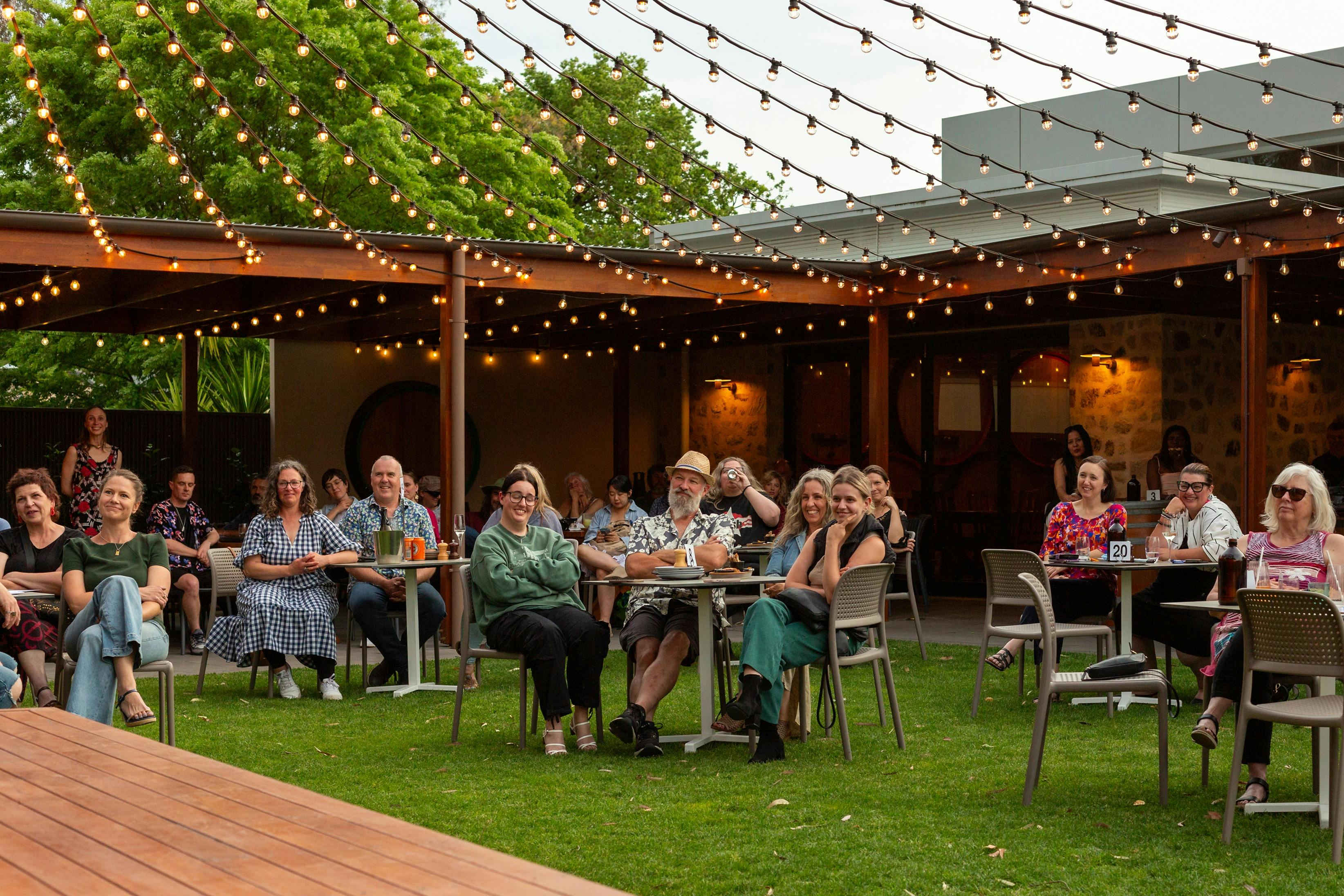Groups of people around tables looking toward the stage