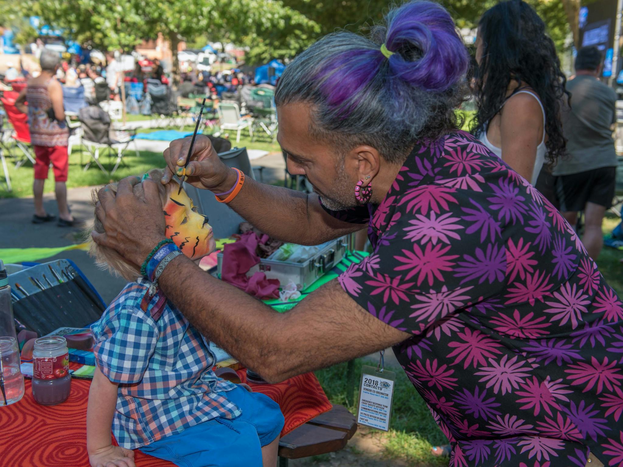 Boy having his face painted like a tiger