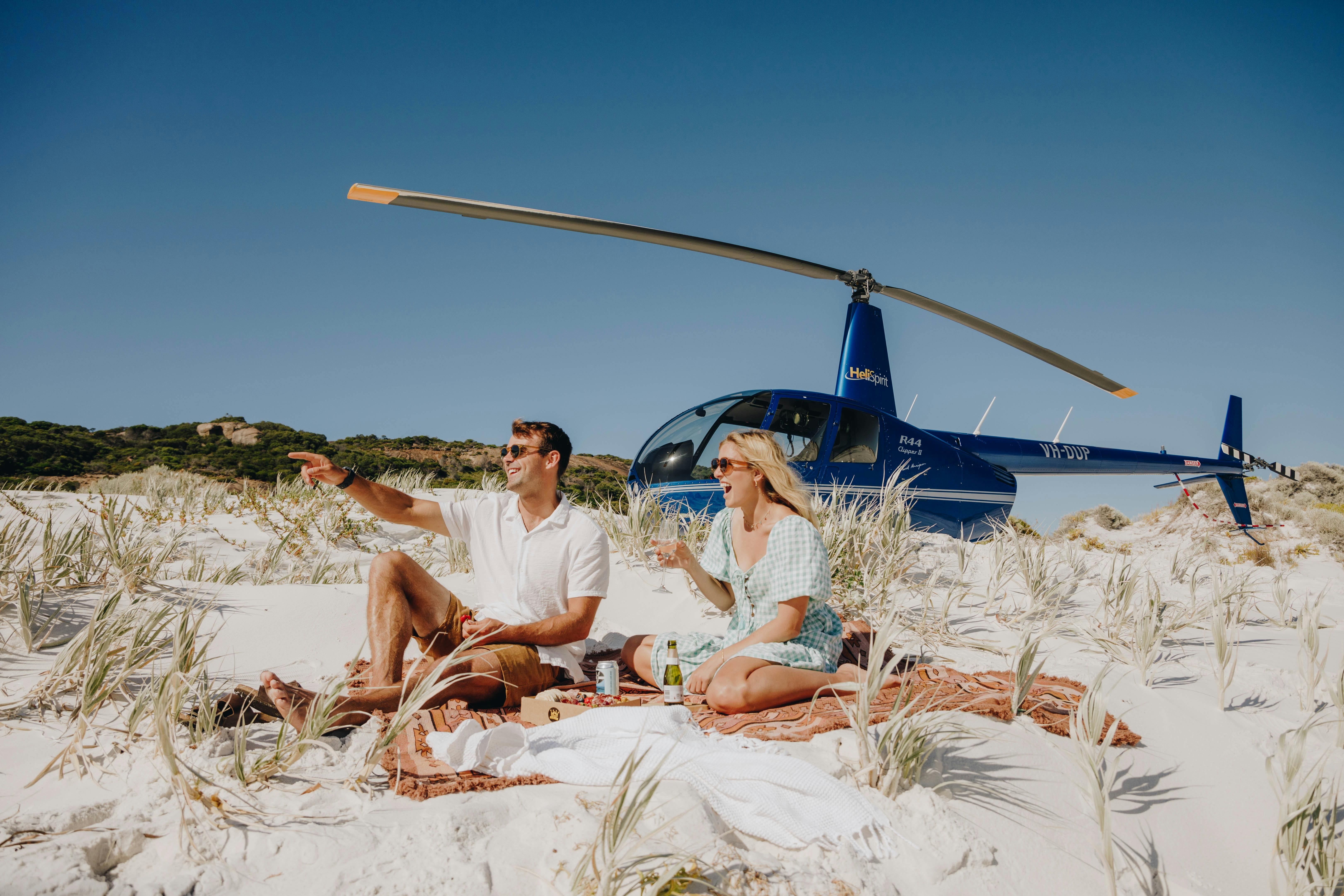 Couple enjoying picnic on beach landing heli flight