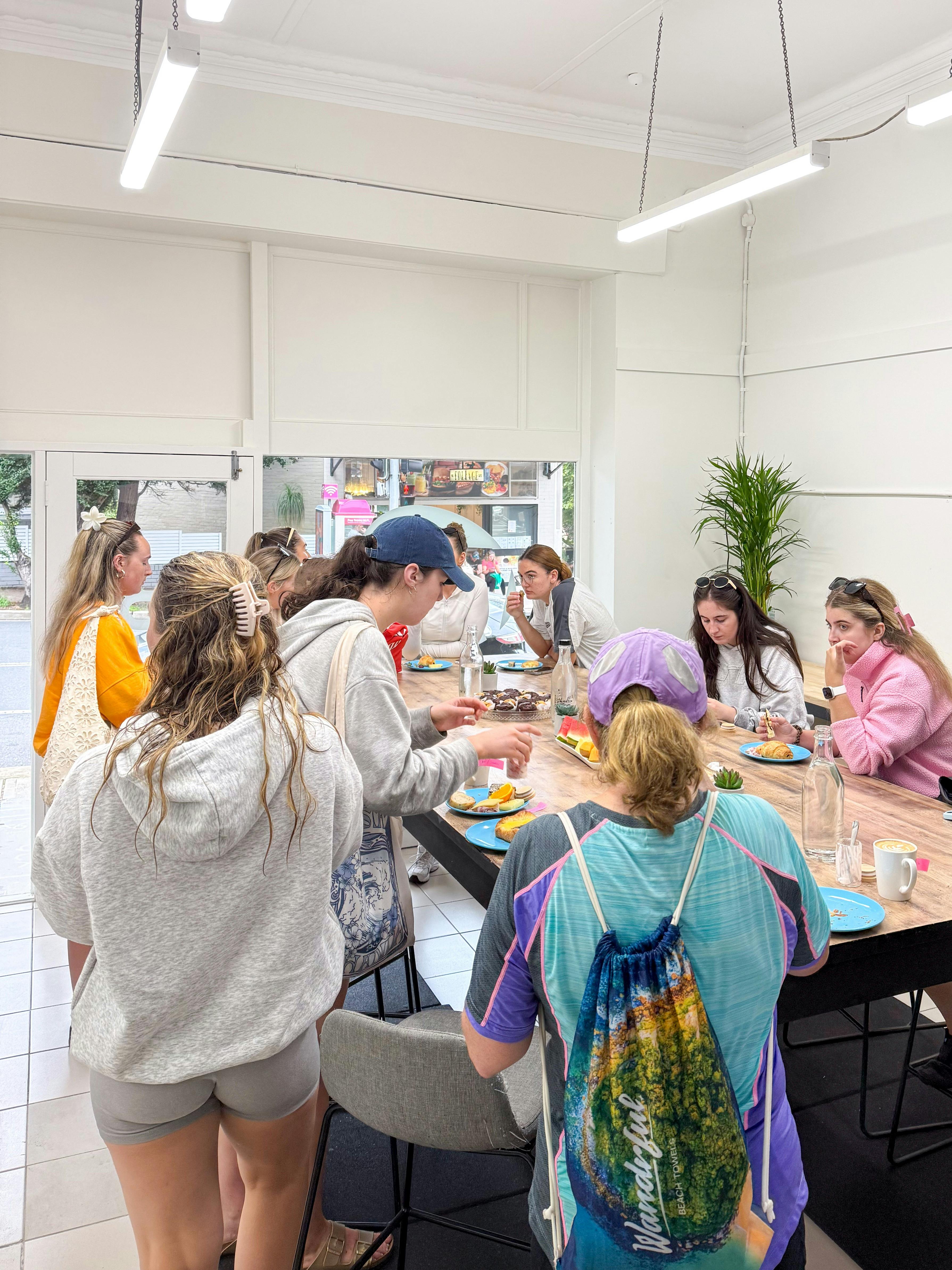 Customers all sit around sharing stories about their kayak experience with food and coffee.