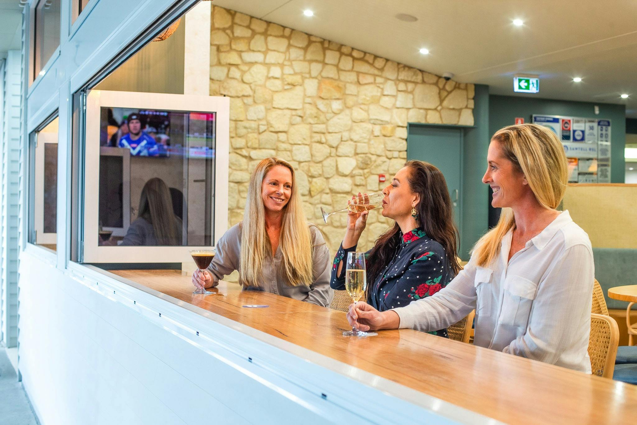 3 ladies enjoying a drink at the bar