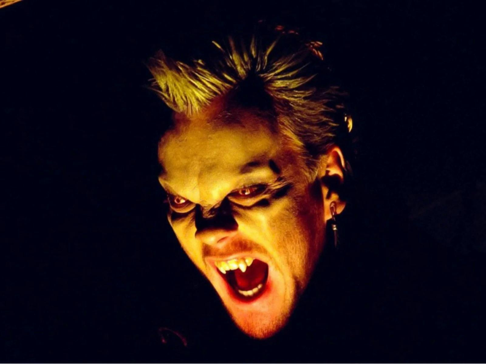 Close up of vampire baring teeth with glowing eyes