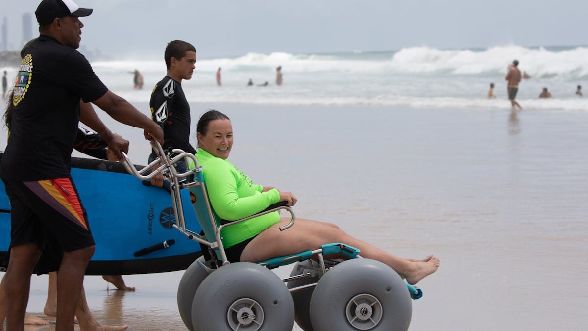 Woamn smiles in beach wheelchair