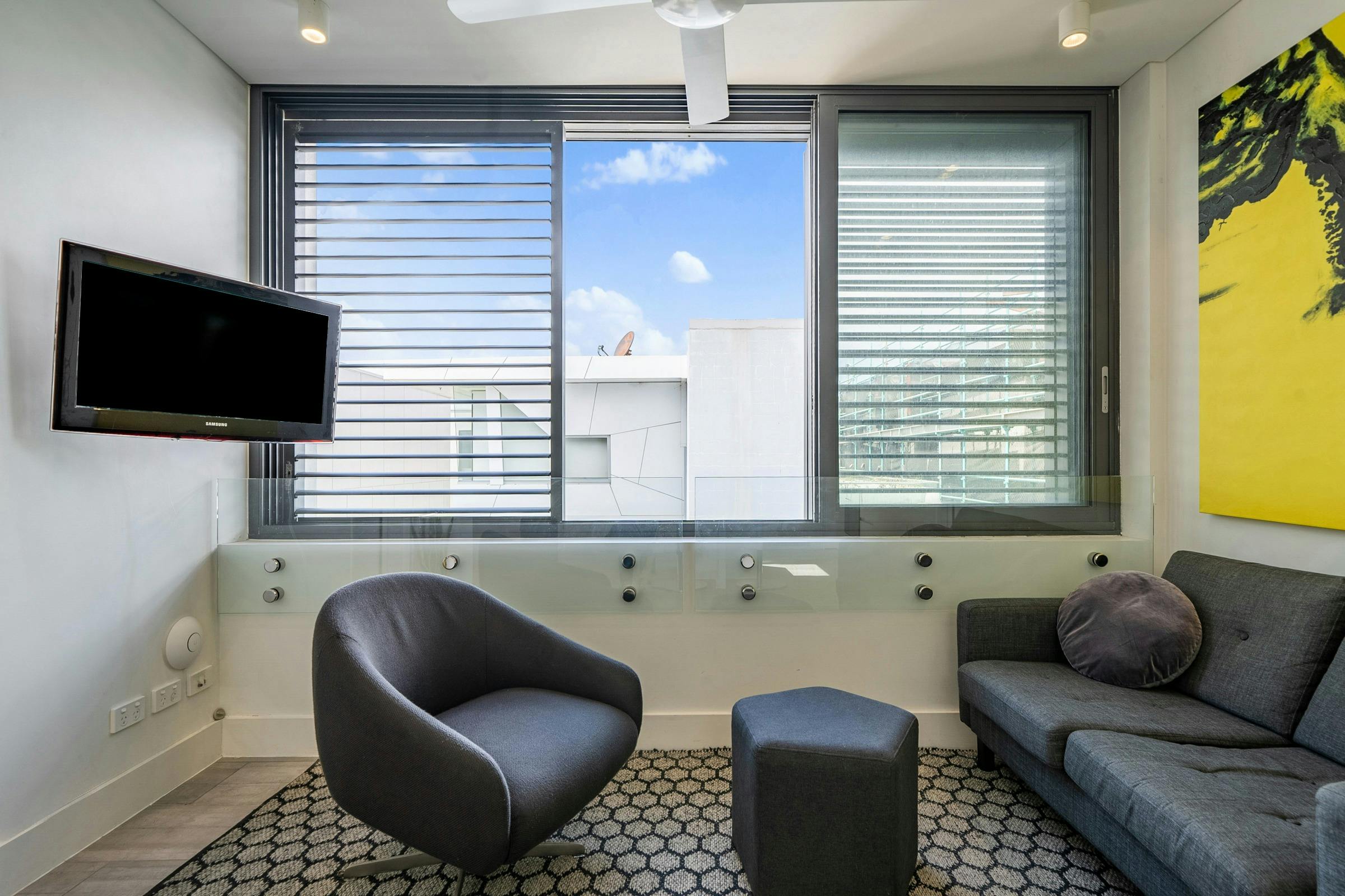 Contemporary living space with kitchen, lounge, and large windows offering natural light.