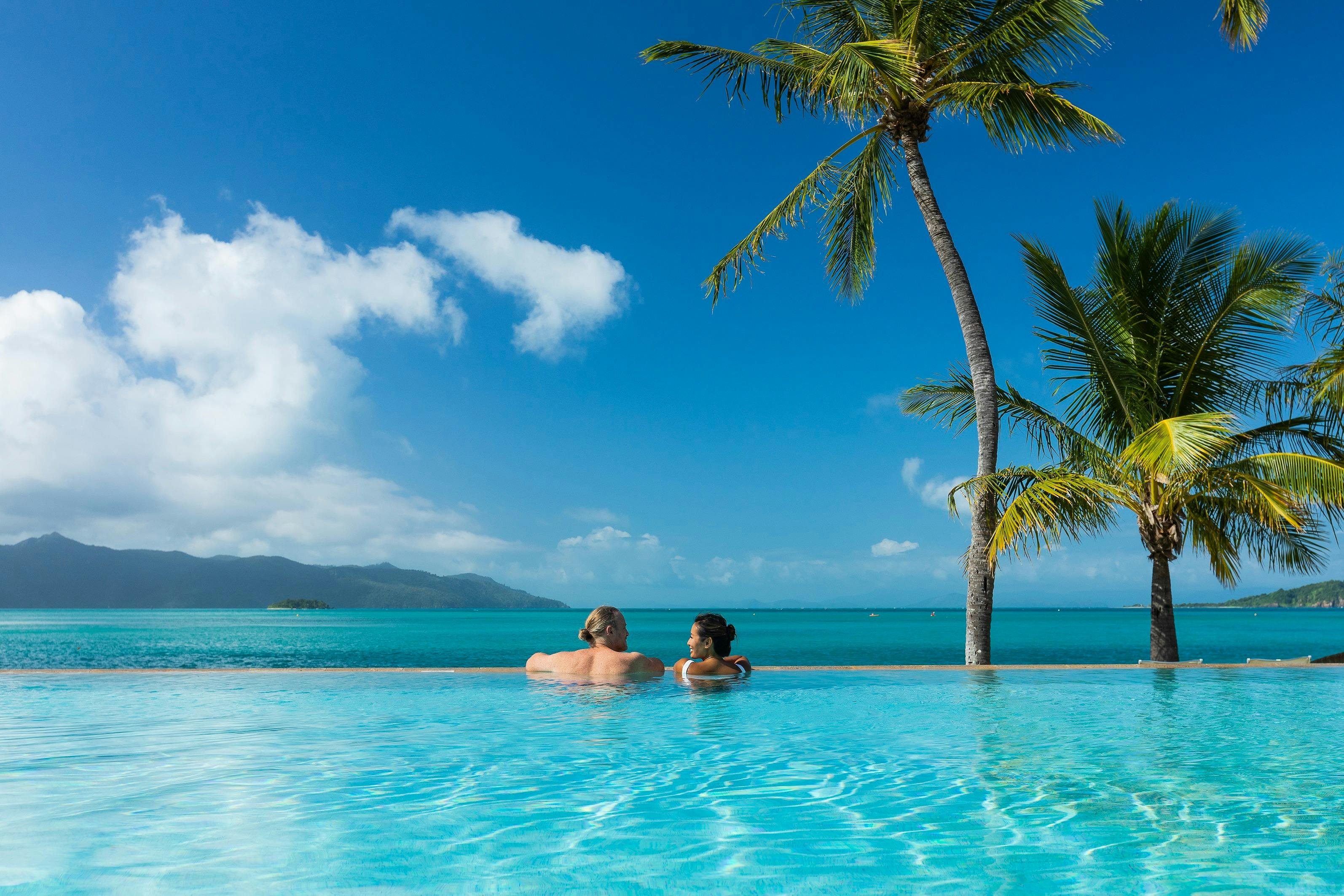 A couple enjoying the ocean views from an infinity pool